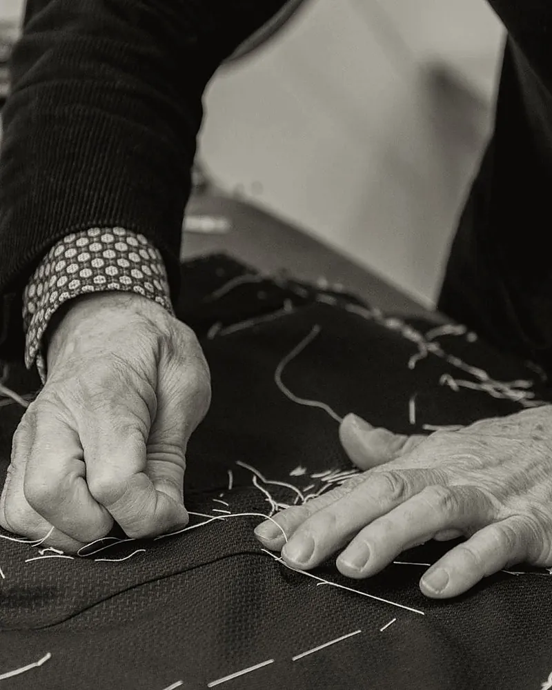 The master tailor’s hands sewing by hand, black and white